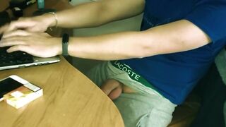 Teen boy jerking off by the desk while working online