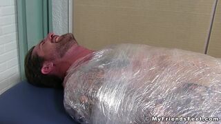 Jock Clint wrapped up to have his feet tickled BDSM style